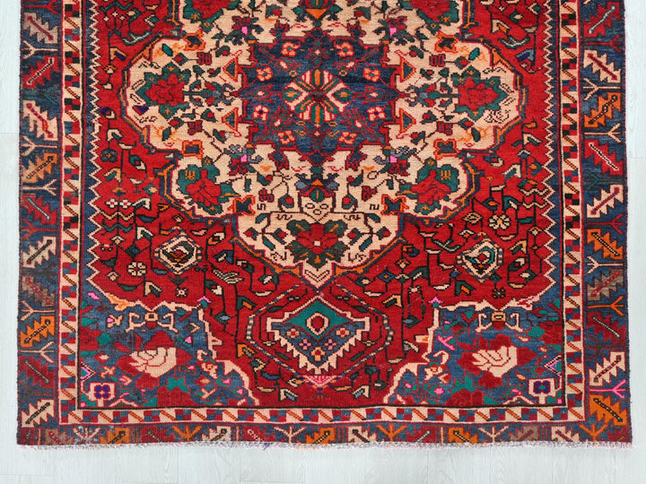 a red and blue rug with an intricate design