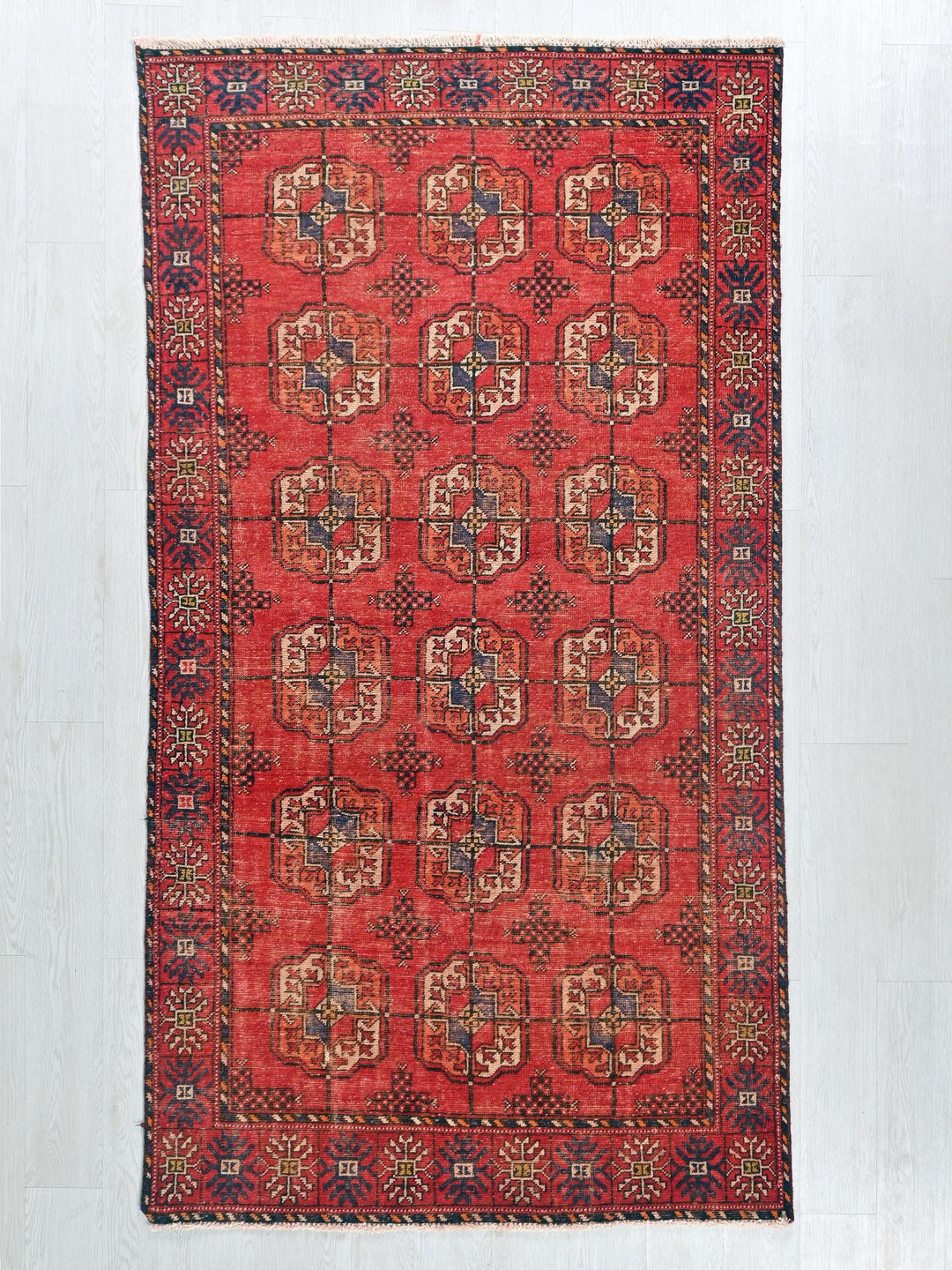 a red rug with a design on the middle of it