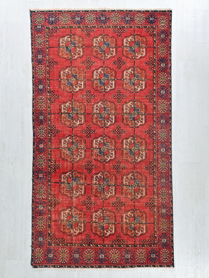 a red rug with a design on the middle of it