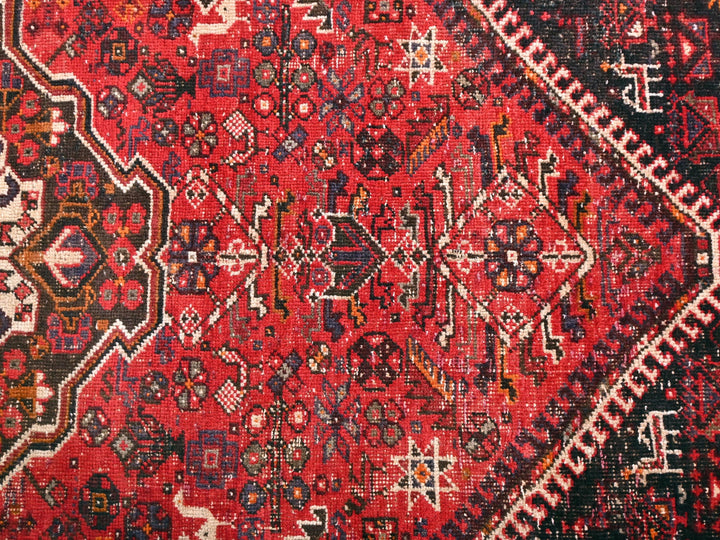 a red oriental rug with a black border