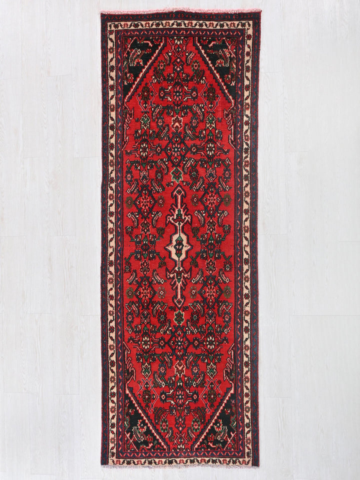 a red rug hanging on a white wall