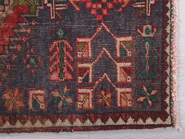 an old rug with a house and trees on it