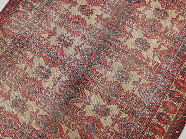 a red and beige oriental rug on a white floor