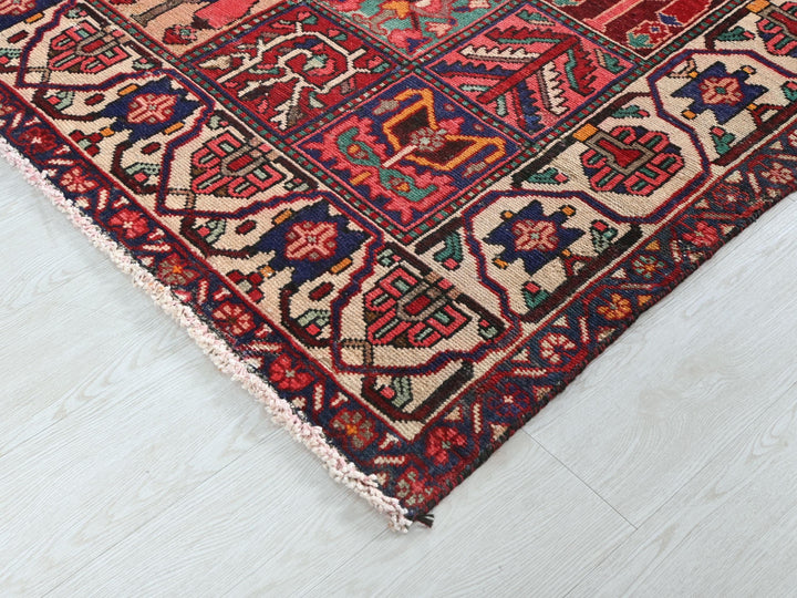 a red rug with a colorful design on a white floor