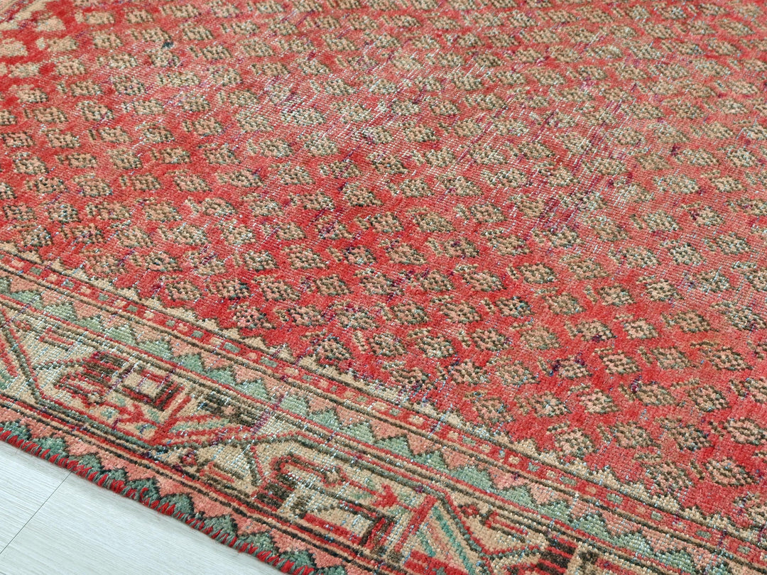 a red rug with a blue border on a white floor