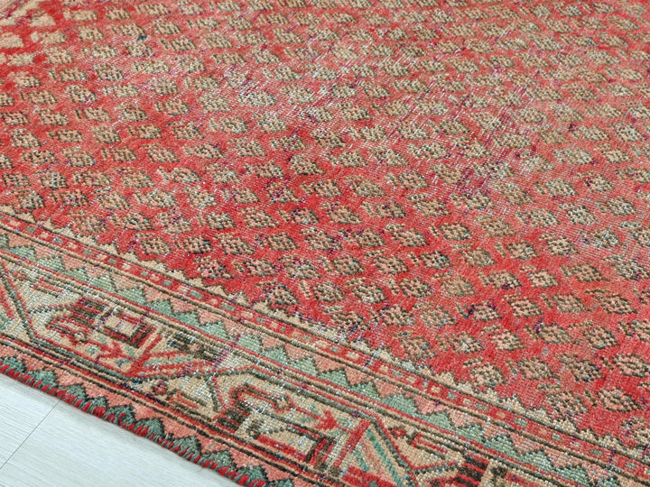 a red rug with a blue border on a white floor