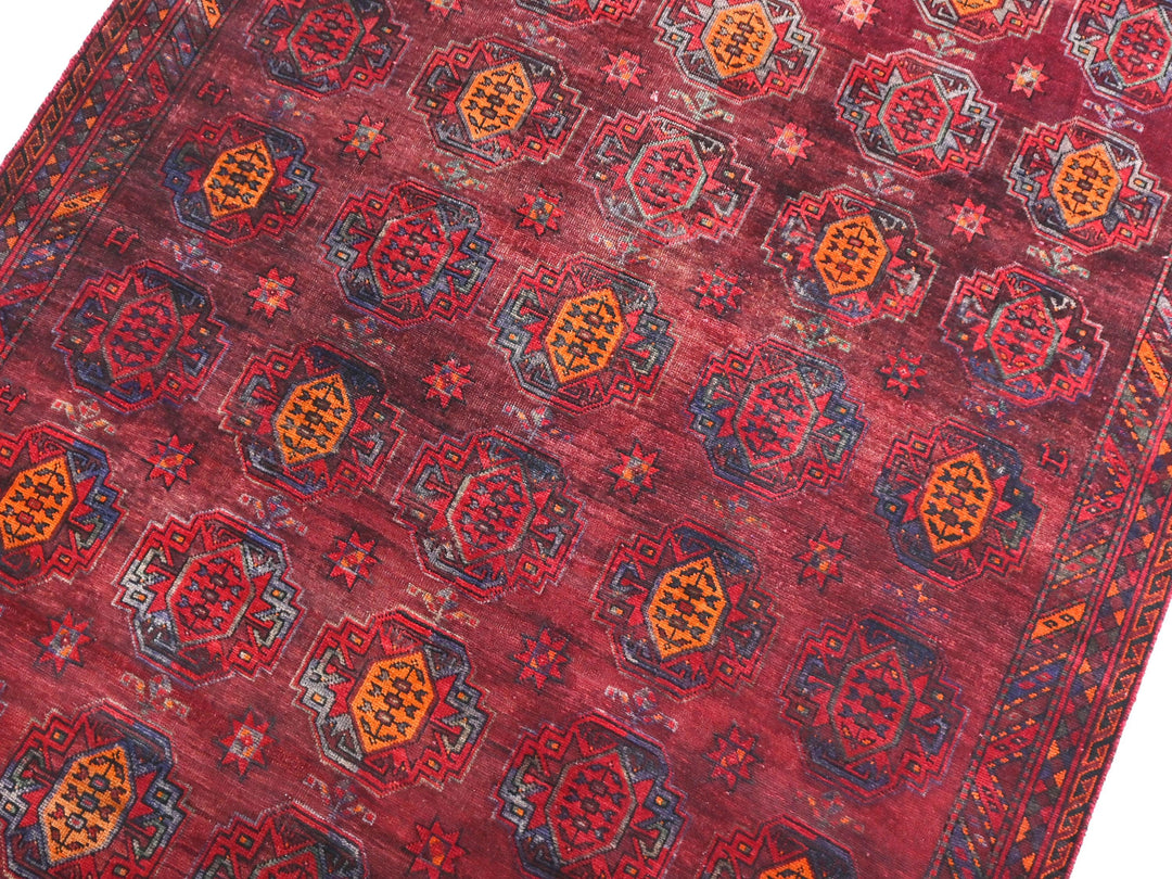 a red oriental rug with an intricate design