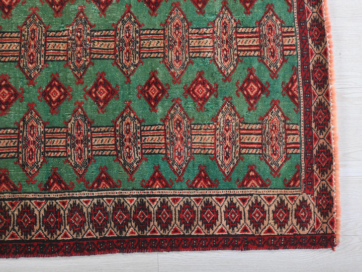 a green and red rug on a white surface