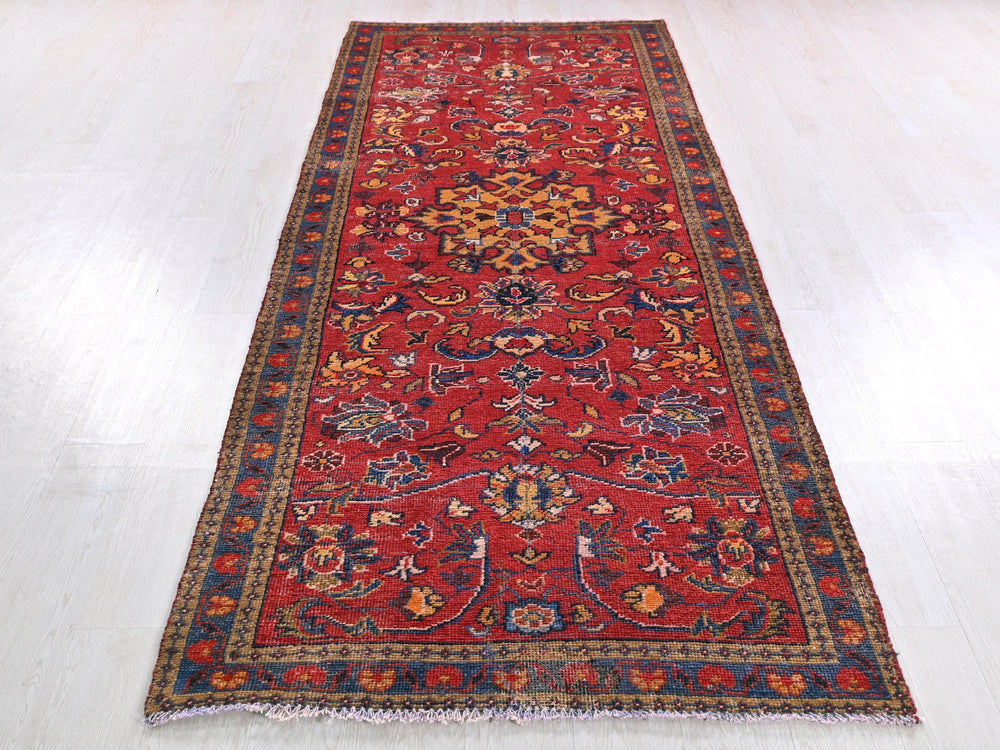 a long red rug on a white floor