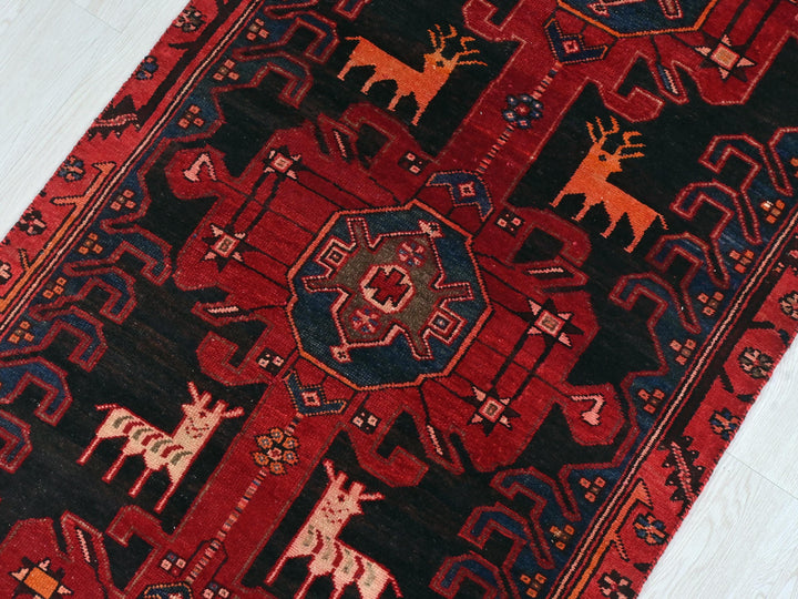 a red rug with animals on it on a white floor