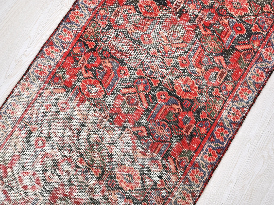 a red and blue rug on a wooden floor