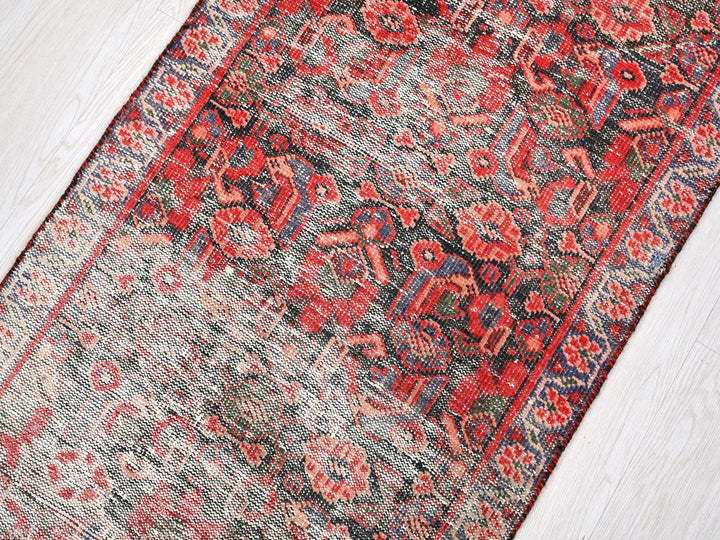a red and blue rug on a wooden floor