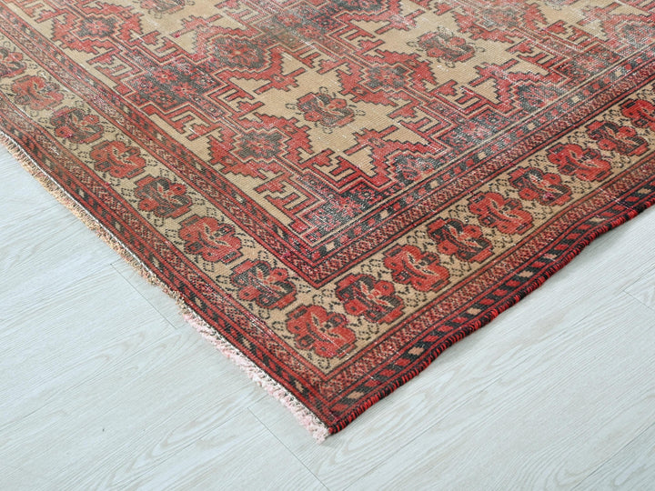 a red and beige oriental rug on a white floor