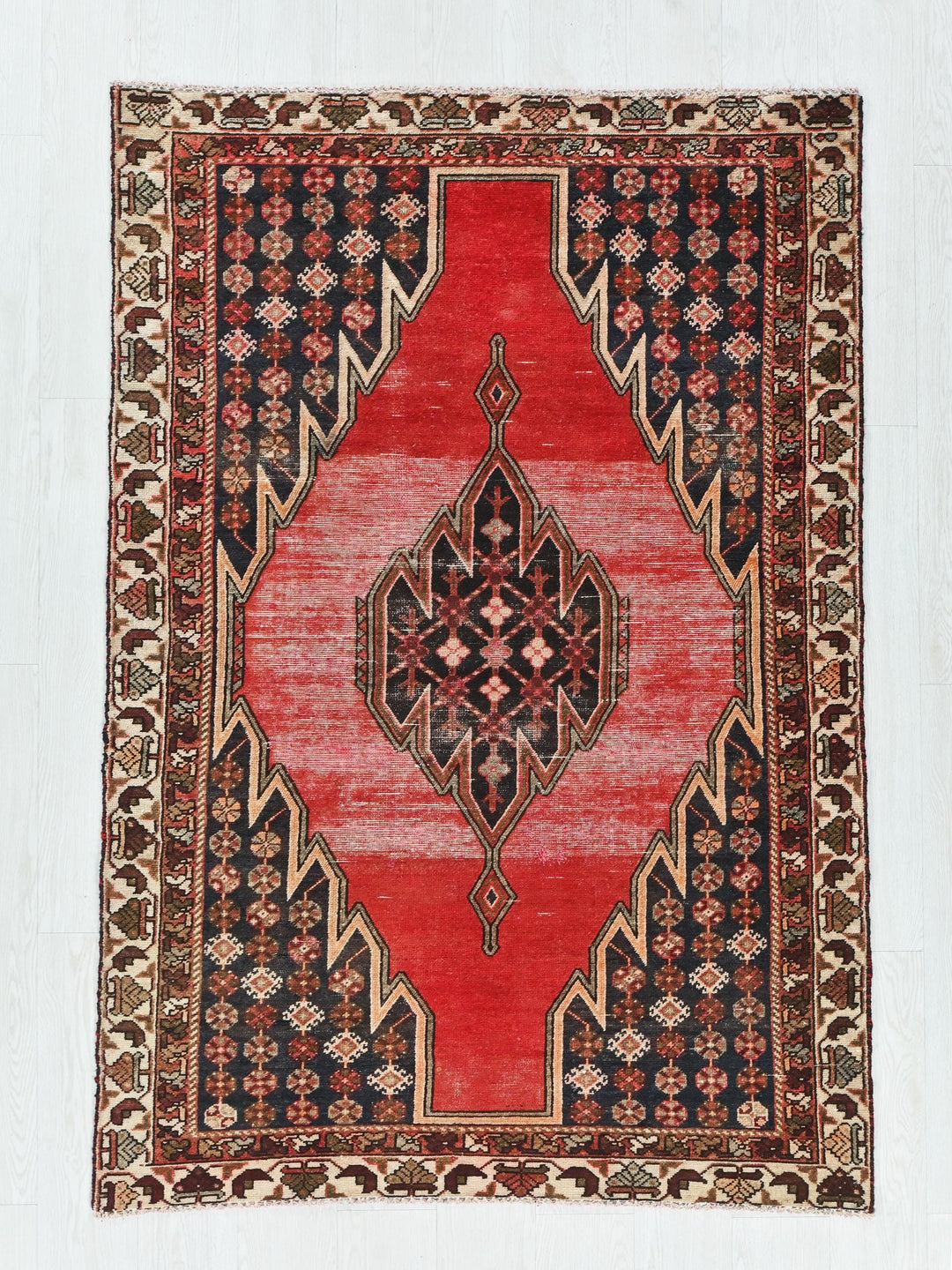 a red and black rug on a white floor