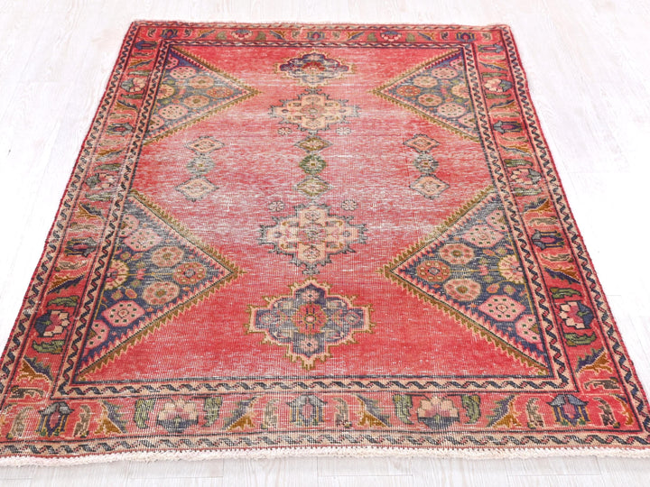 a red rug with a design on the middle of it