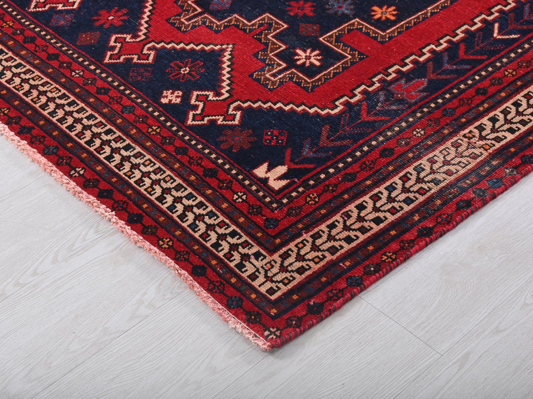 a red and blue rug on a white floor