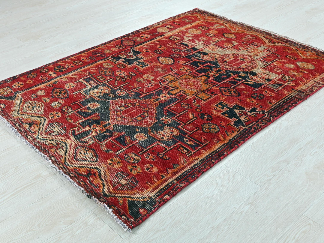a red and black rug on a white floor