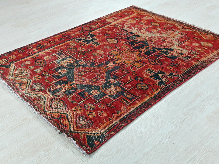 a red and black rug on a white floor