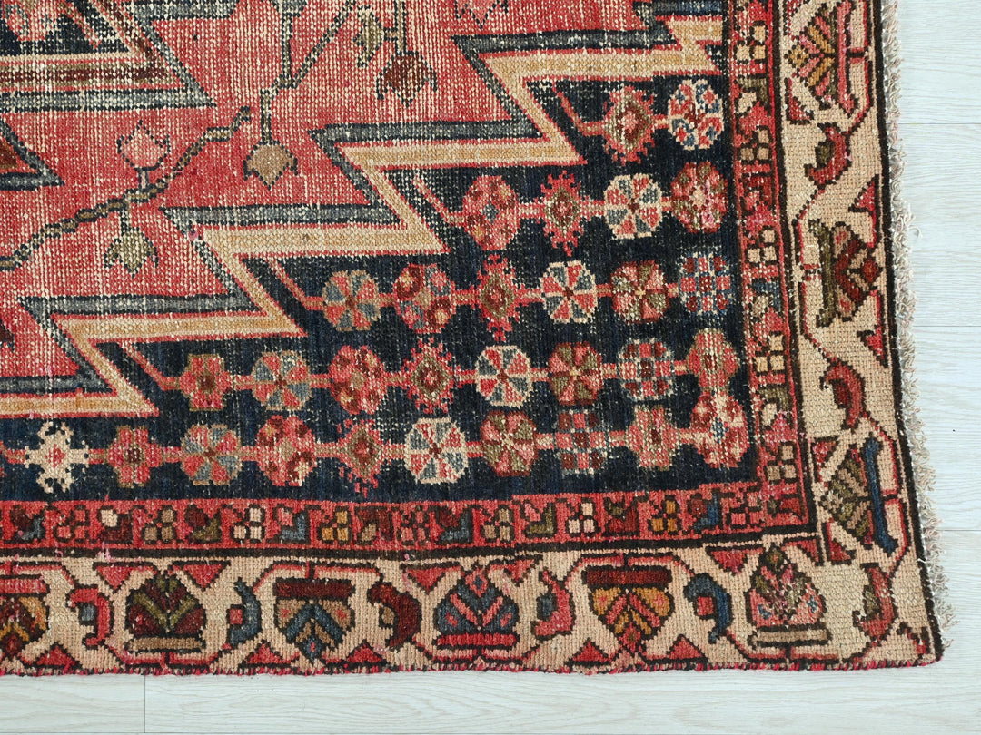 a red rug with a design on the middle of it
