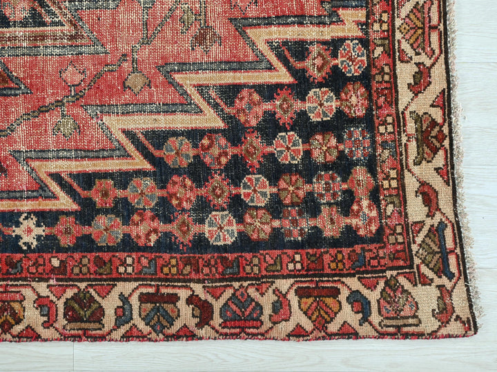 a red rug with a design on the middle of it