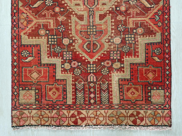 a red and beige rug with a design on it