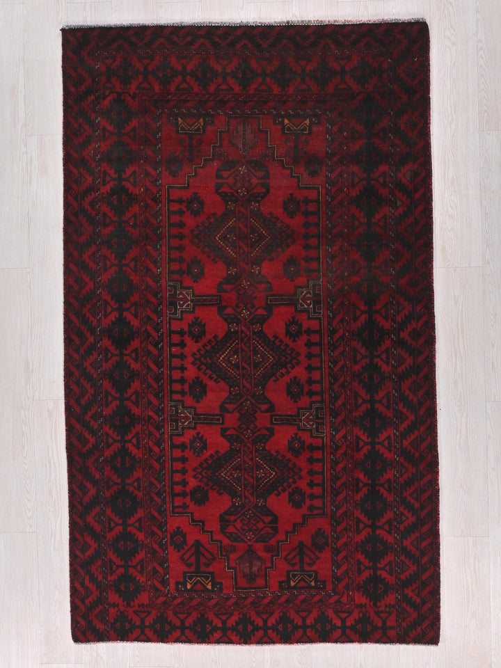 a red and black rug on a white floor