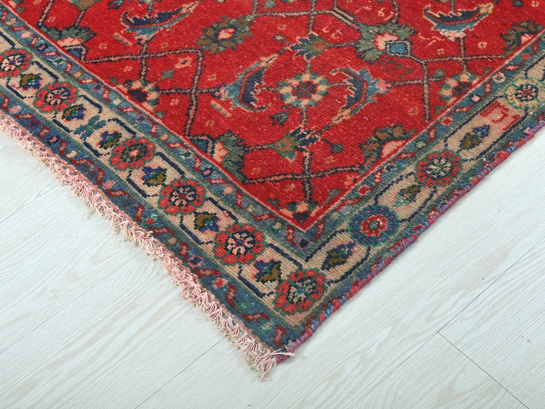 a red rug on a white wooden floor