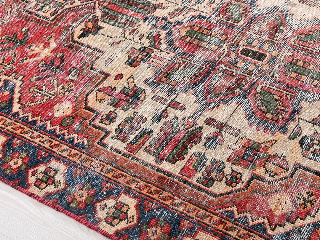 a red and blue oriental rug on a wooden floor