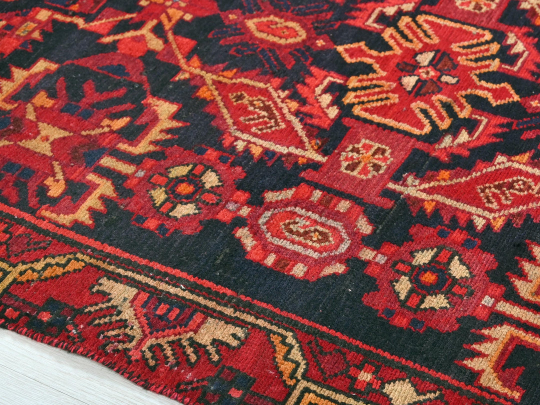 a close up of a red rug on a wooden floor