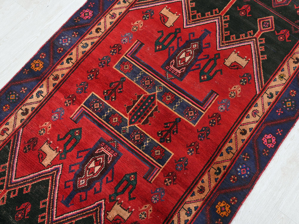 a red and black rug on a white floor