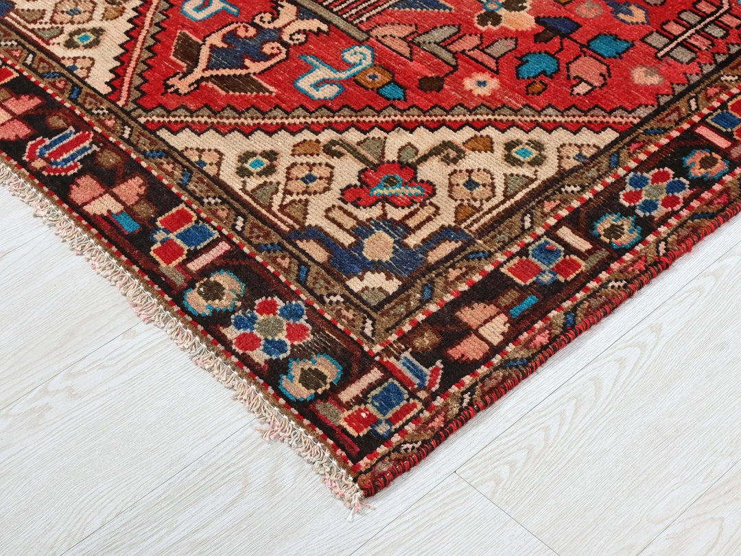 a red and blue oriental rug on a white floor