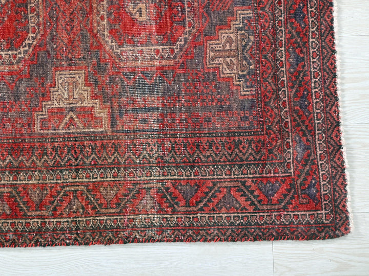 a red rug with a design on the middle of it