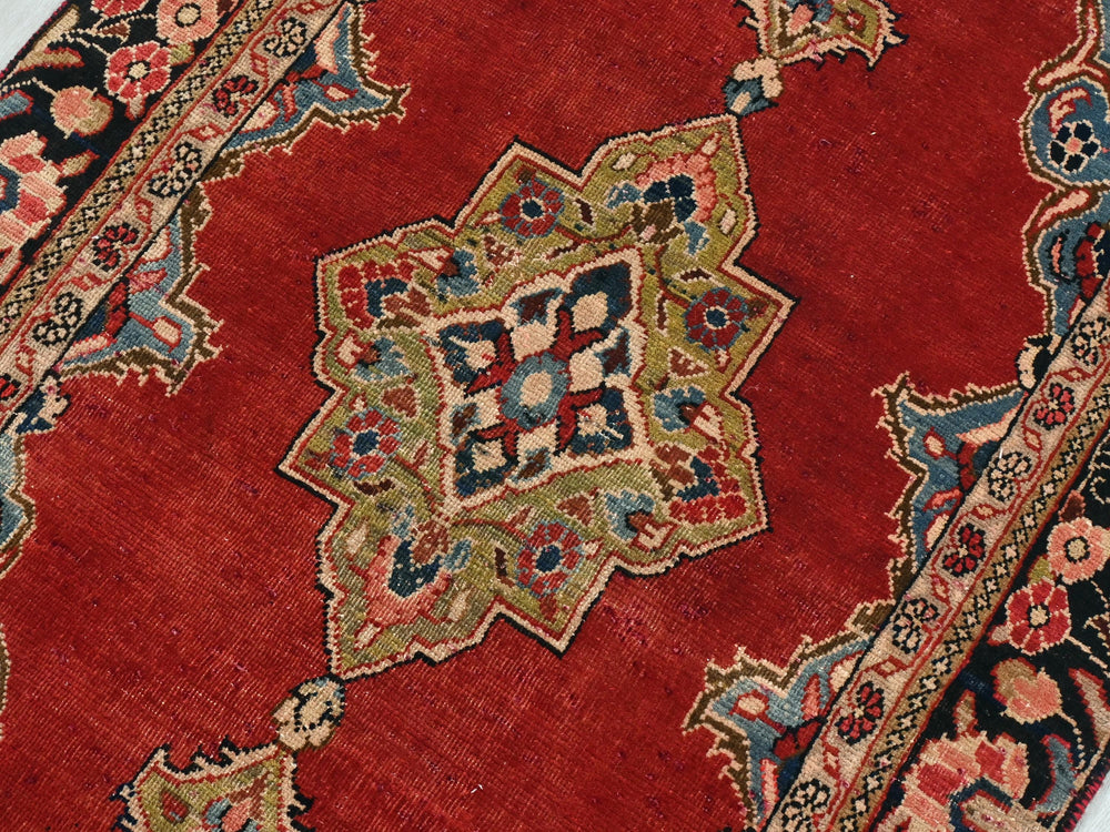 a close up of a red rug on a white floor