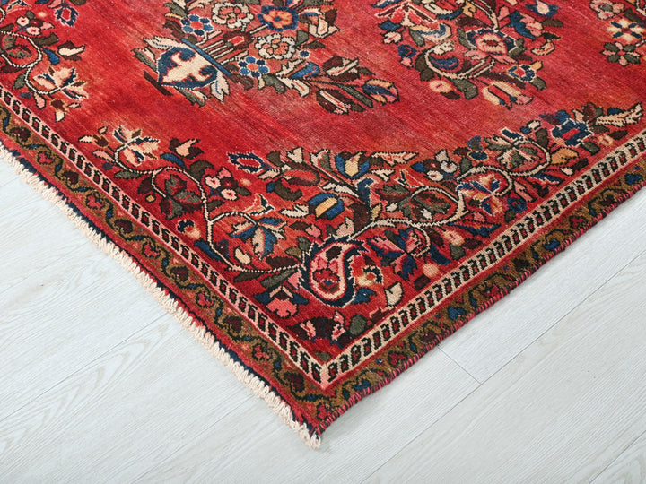 a red oriental rug on a white wooden floor