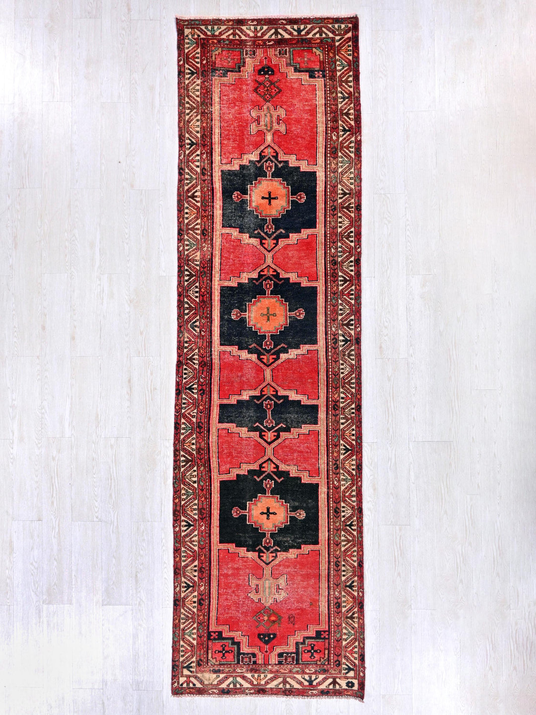 a red and black rug hanging on a wall