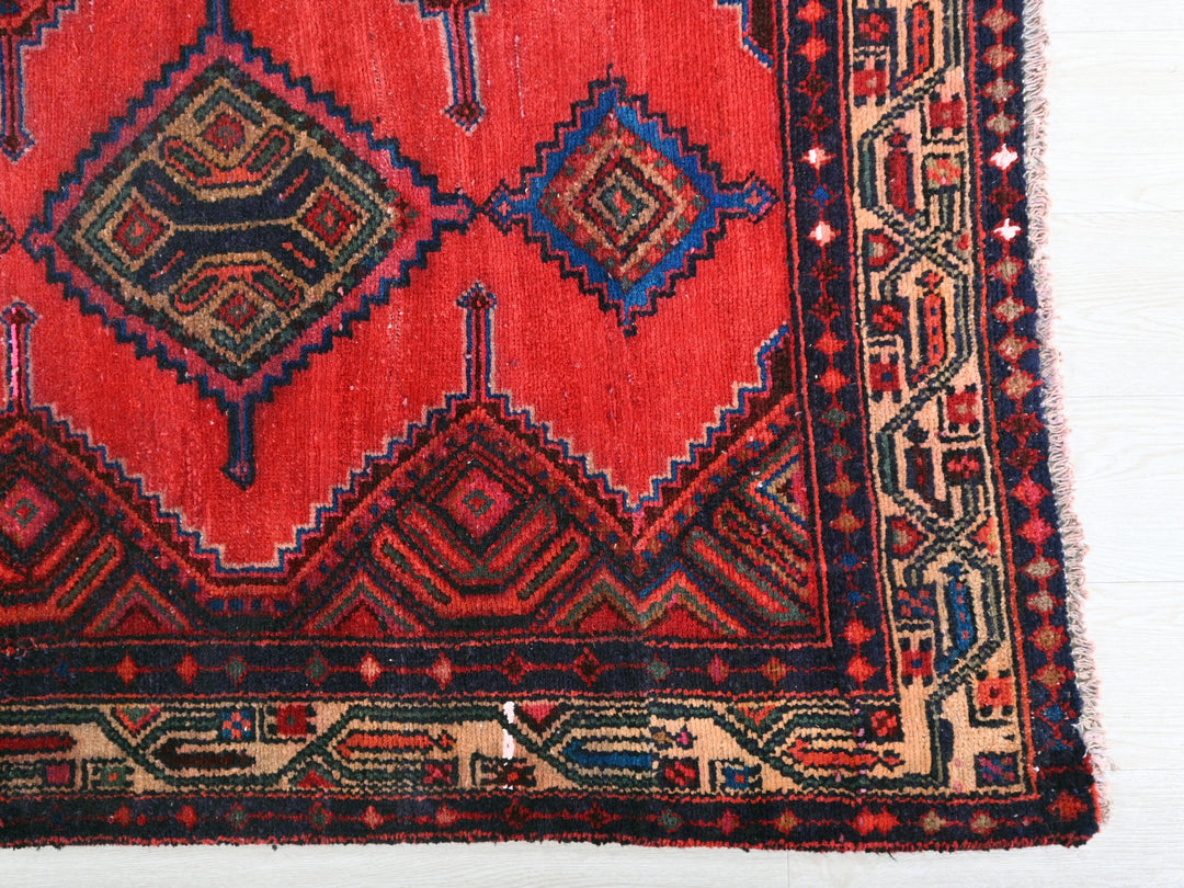 a red rug with a diamond pattern on it