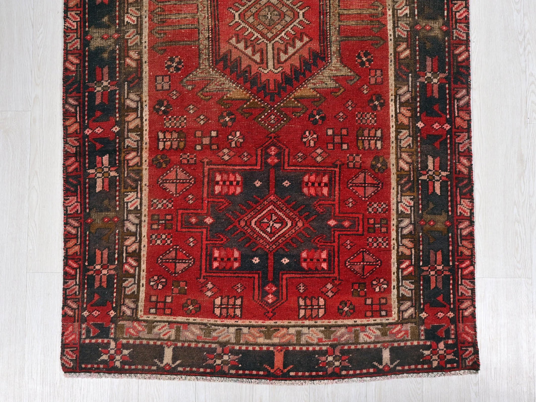 a red and black rug on a white floor
