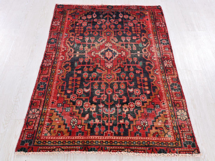 a red and black rug on a white floor