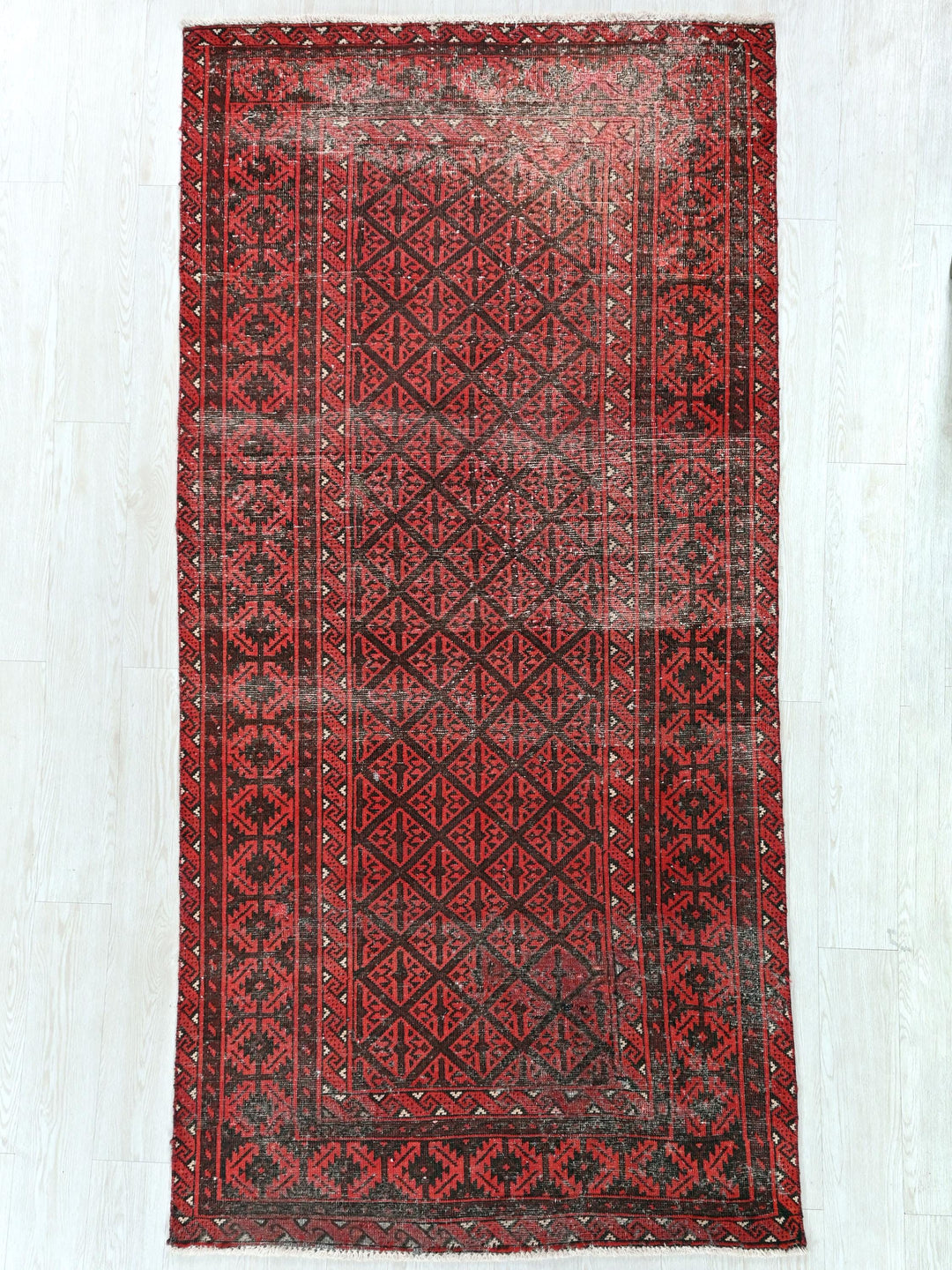 a red and black rug on a white floor