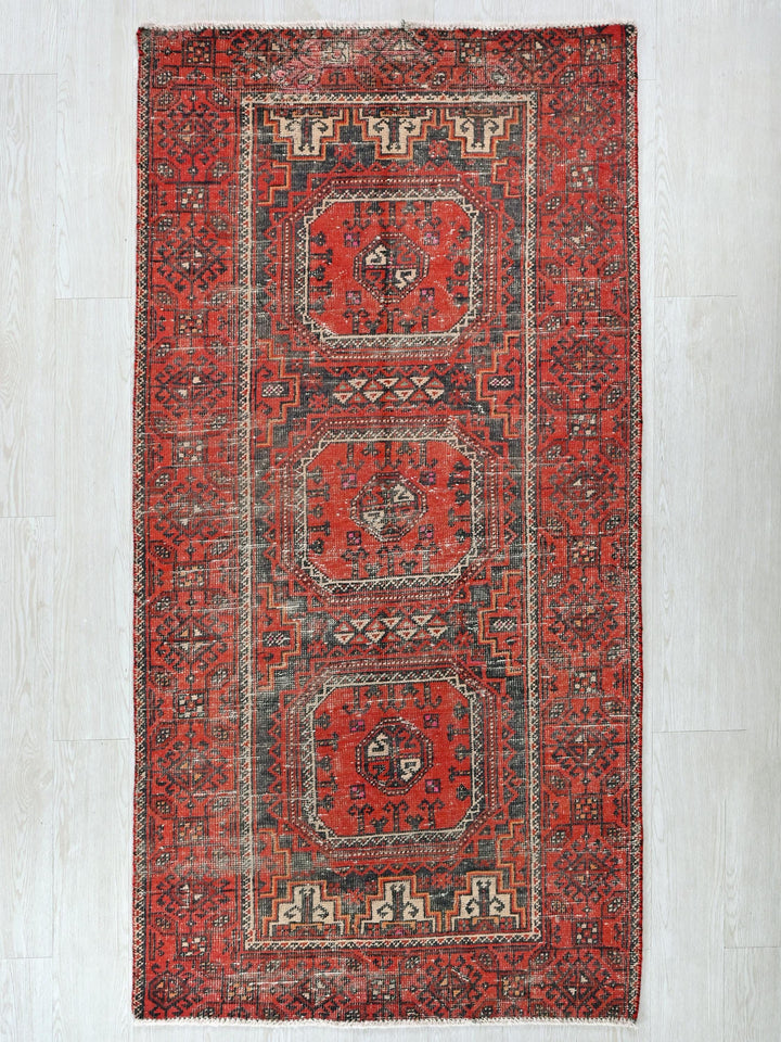 a red rug with a design on the middle of it