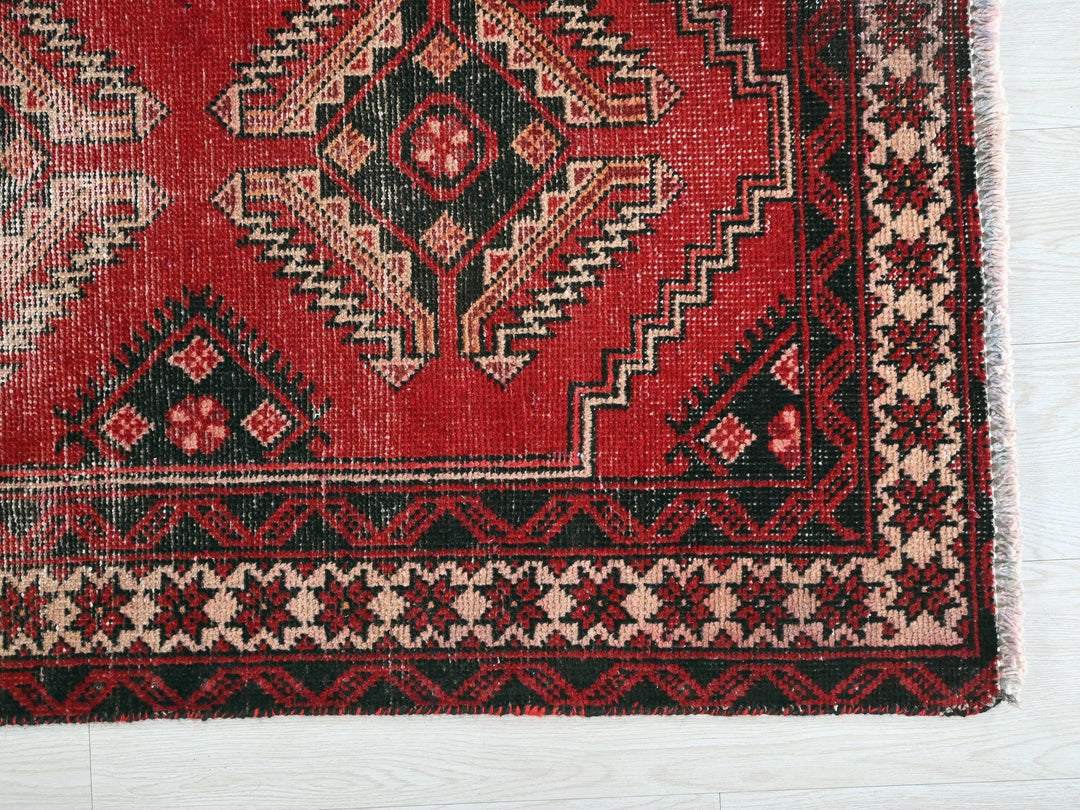 a close up of a red rug on a white surface