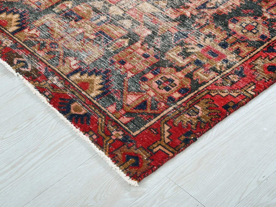 a red, blue, and beige oriental rug on a white floor