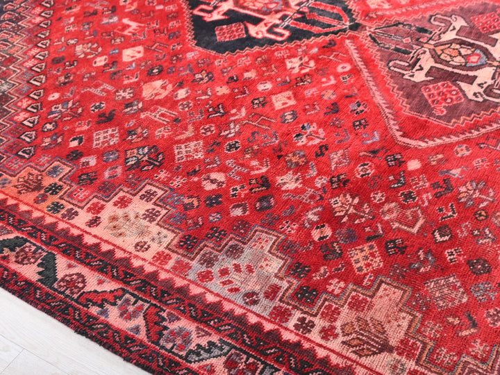 a red oriental rug with a black border