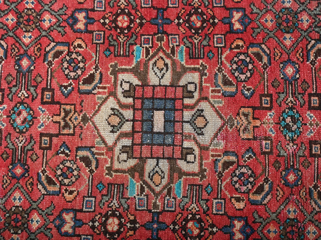 a red rug with a design on it