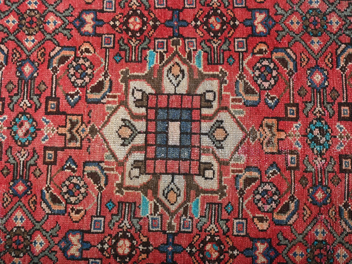 a red rug with a design on it