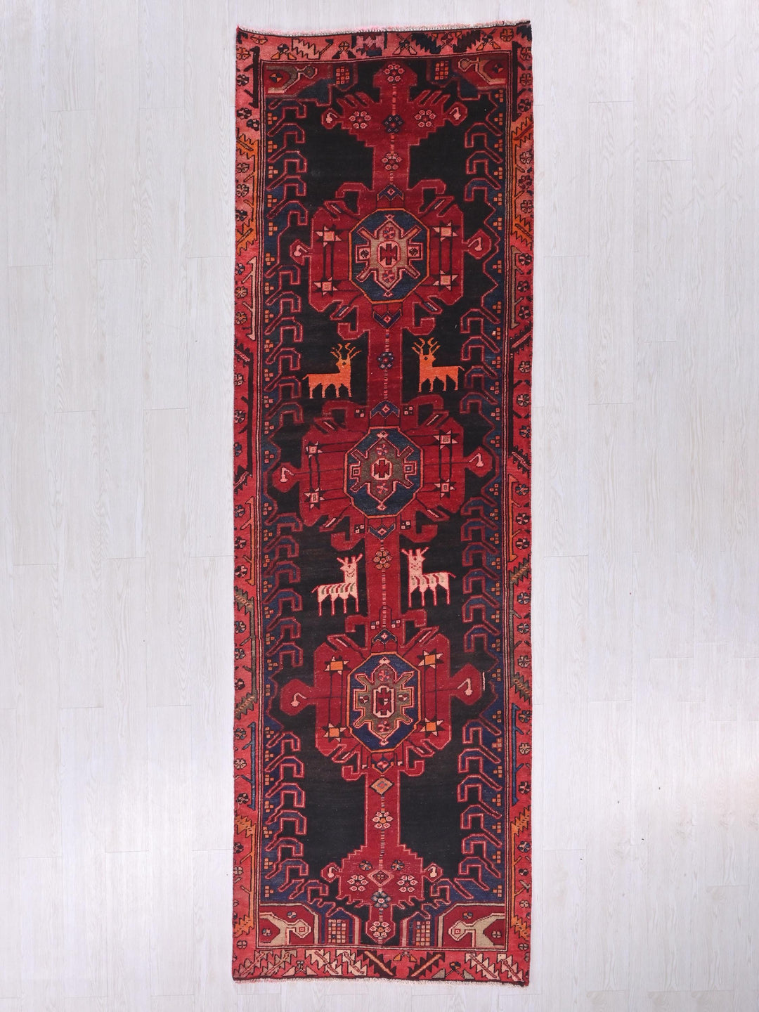 a red and black rug hanging on a wall