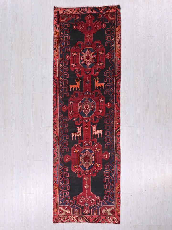 a red and black rug hanging on a wall