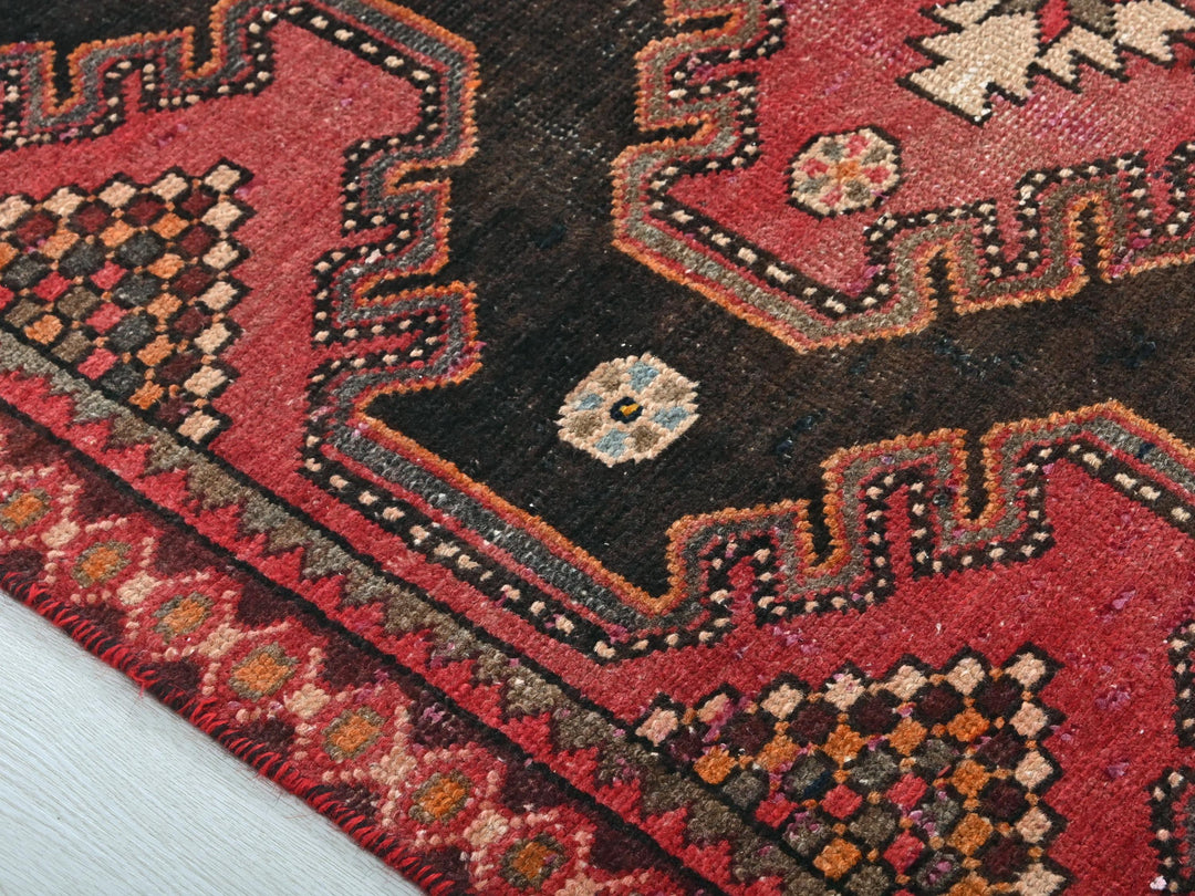 a close up of a red and black oriental rug