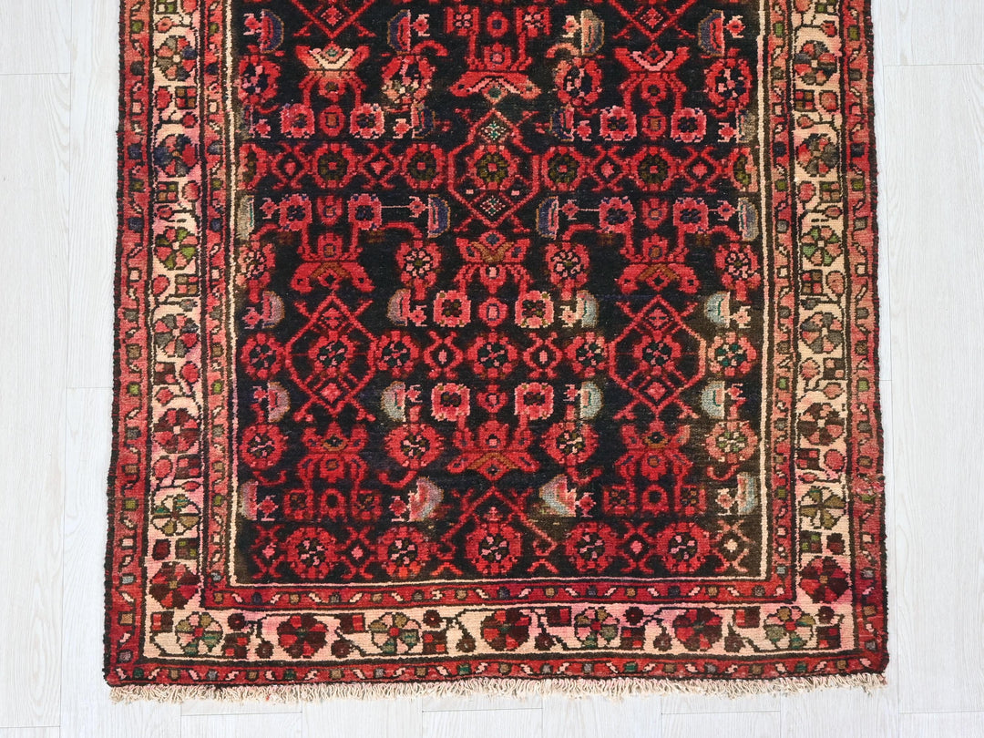 a red and black rug on a white floor