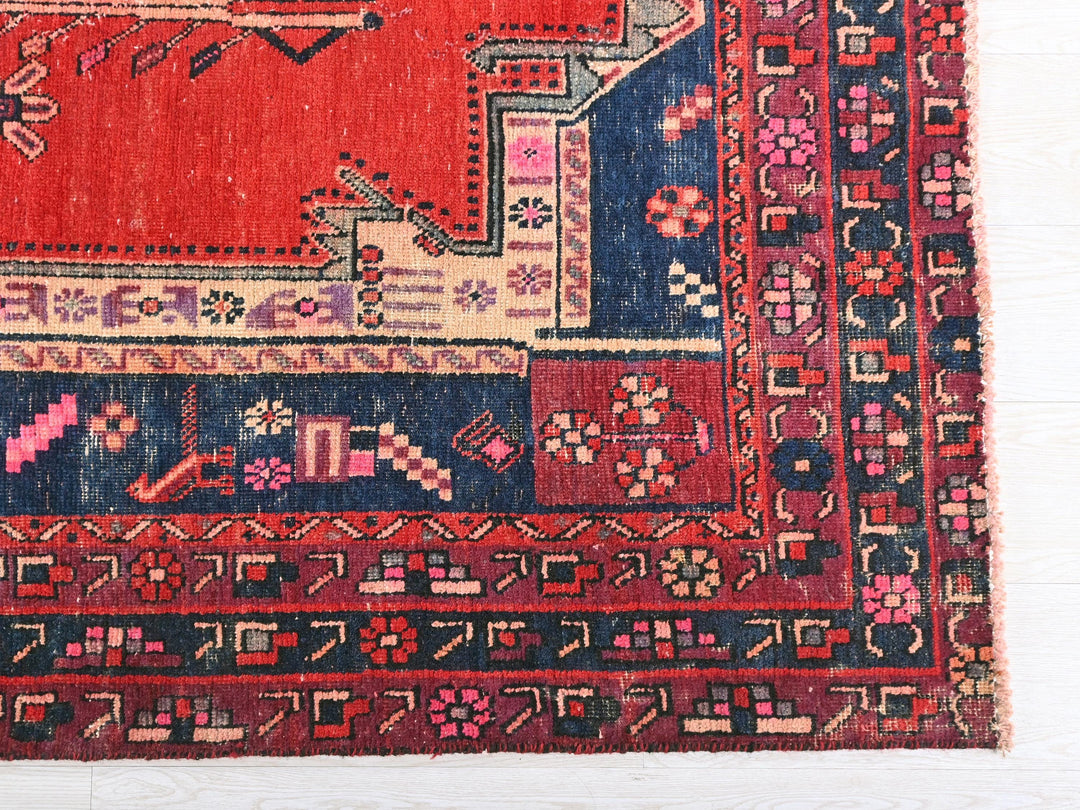 a red, blue, and pink rug on a white surface